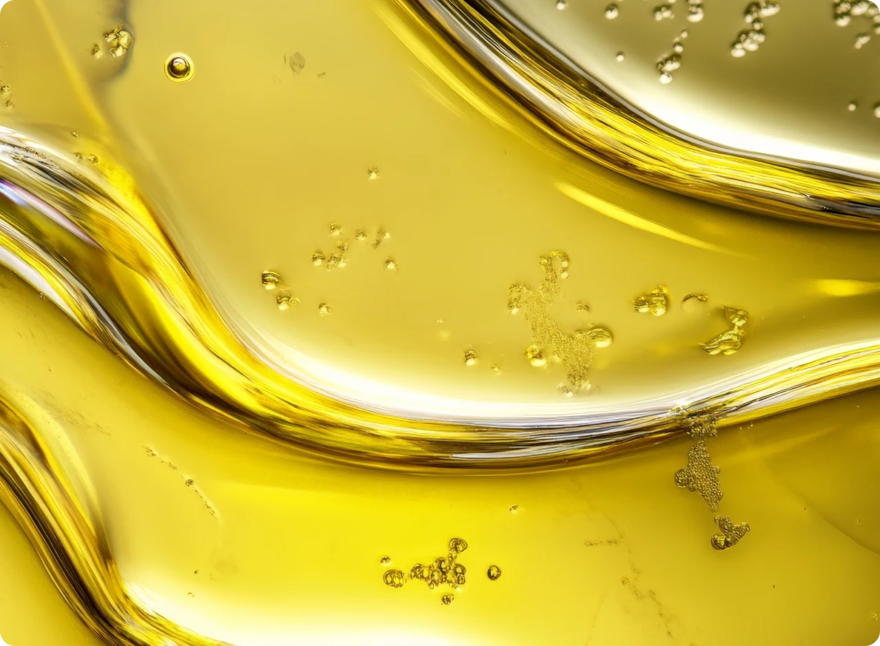 Nahaufnahme von flüssigem Olivenöl mit blasenförmigen Einschlüssen und geschwungenen, goldenen Linien.