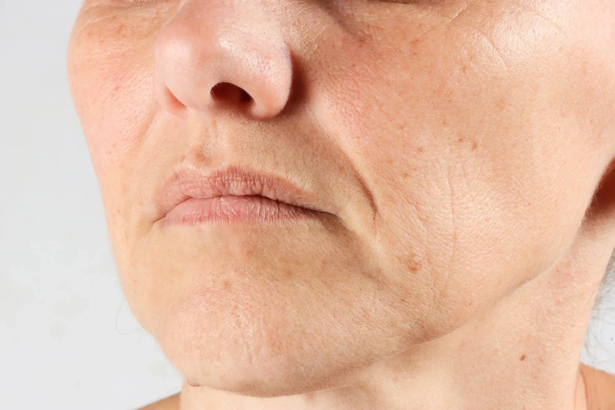Nahaufnahme einer älteren Person mit sichtbaren Falten auf der Stirn und um die Augen