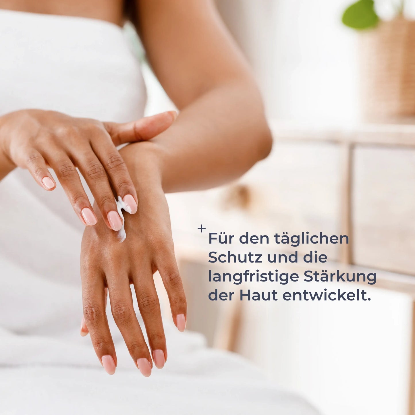 
                  
                    Frau trägt Handcreme auf die Hand auf, Text: 'Für den täglichen Schutz und die langfristige Stärkung der Haut entwickelt.'
                  
                